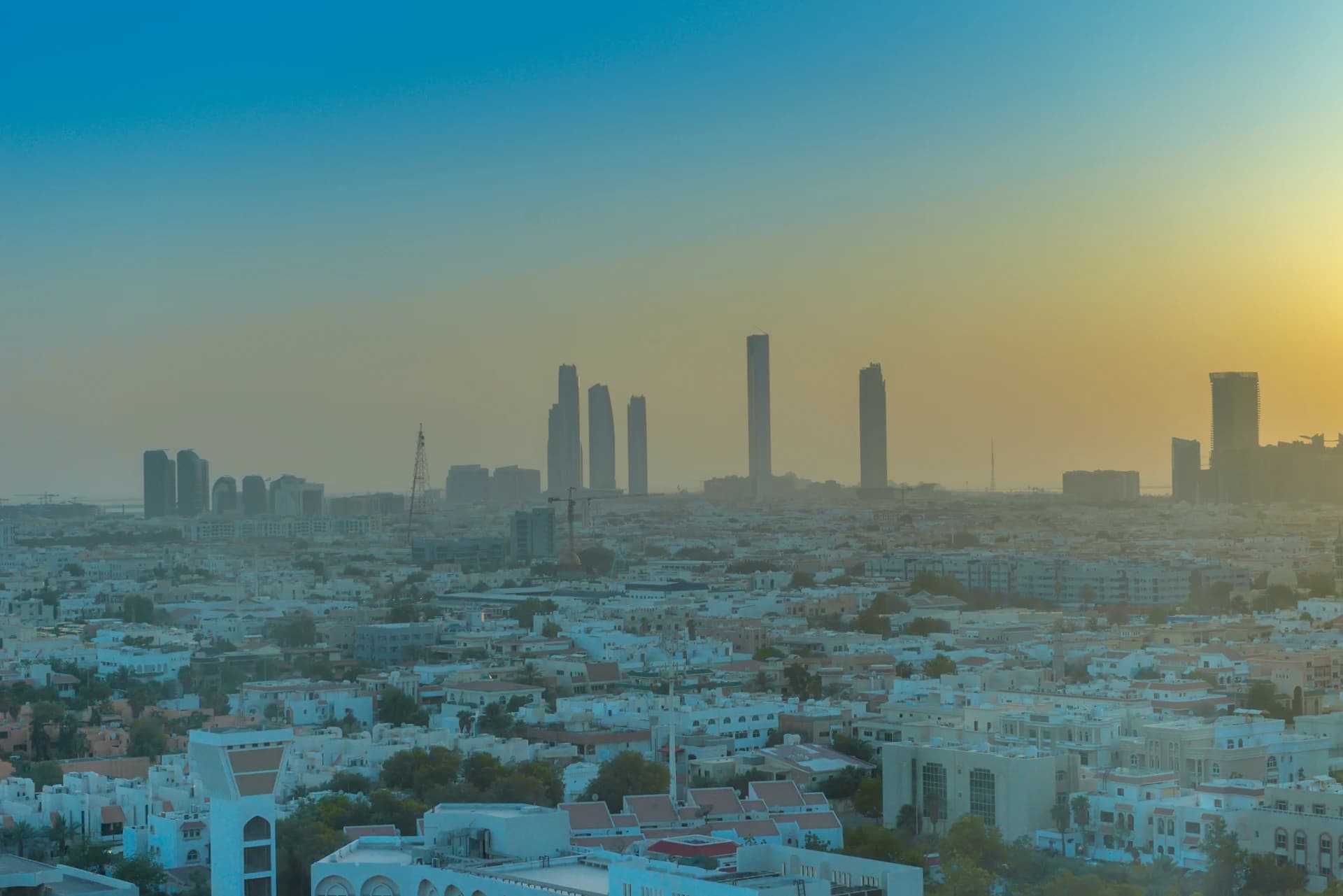 A broad view across Abu Dhabi low-rise neighbourhoods towards distant towers in 2015